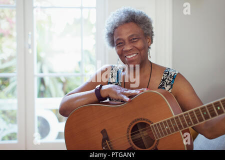 Portrait smiling, confident active senior woman playing guitar Stock Photo