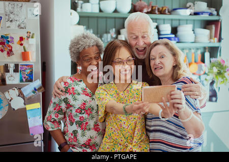 Happy, playful active seniors taking selfie with camera phone, making silly faces Stock Photo