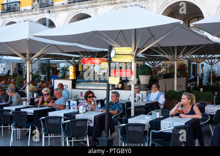 Directional street signs for cities of the world in front of a cafe in Lisbon, Portugal Stock Photo