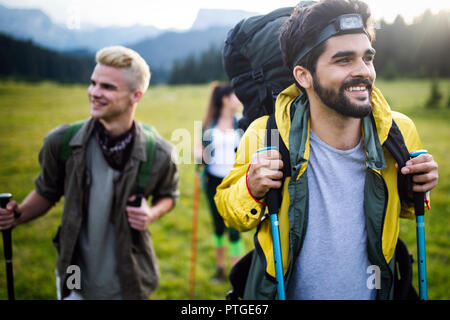 Hiking with friends is so fun. Group of young people with backpacks walking together Stock Photo
