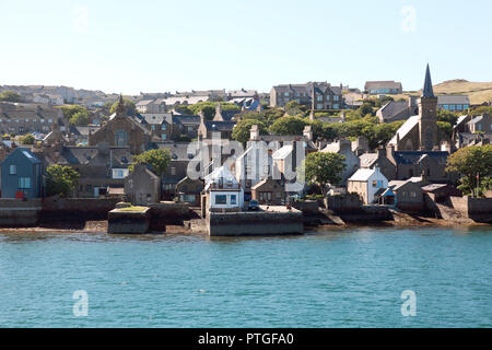 Houses on the edge of the harbour of Stromness in the Orkney Islands with gable ends facing the sea Stock Photo