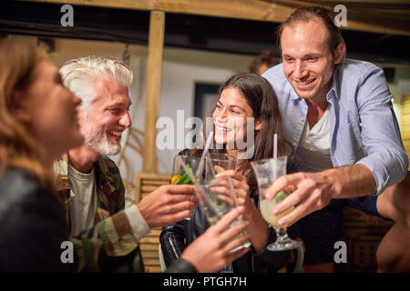 Friends toasting cocktails on patio Stock Photo
