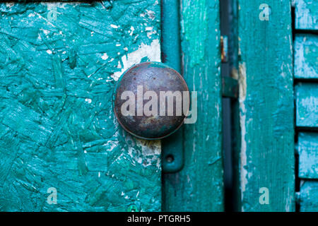 old rusted doorknob on green background Stock Photo