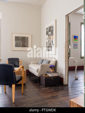 Salvaged linen sofa with 1950’s black leather Bentwood chairs. Artwork by James Turrell. Stock Photo