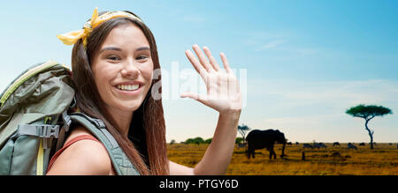 happy woman with backpack over savannah Stock Photo