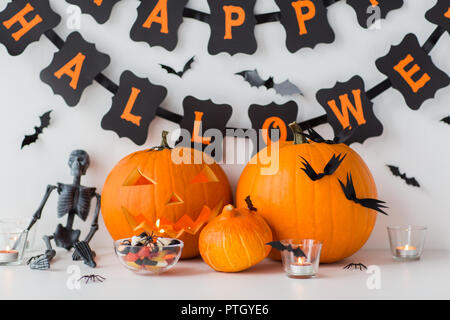 carved pumpkins with candies and halloween garland Stock Photo