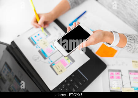 designer with smartphone working on user interface Stock Photo