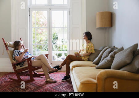 Senior women friends talking in living room Stock Photo