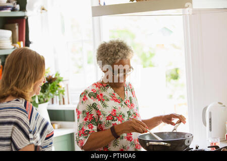 Senior women cooking at stove in kitchen Stock Photo