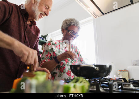 Active senior couple cooking in kitchen Stock Photo