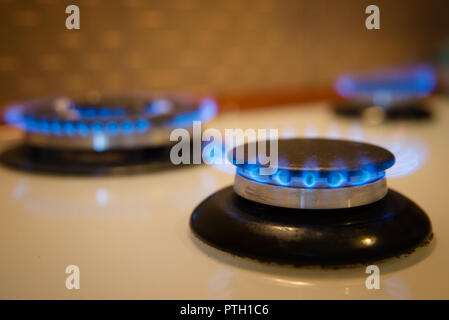 Gas stove at home, natural propane gas burns in kitchen, blue fire