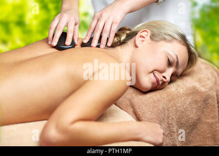 close up of woman having hot stone massage in spa Stock Photo