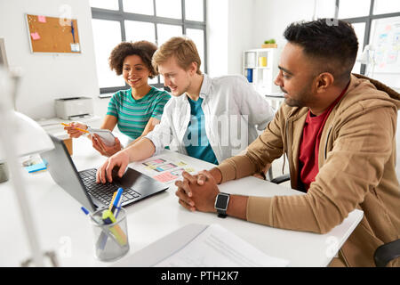 happy creative team with laptop working at office Stock Photo