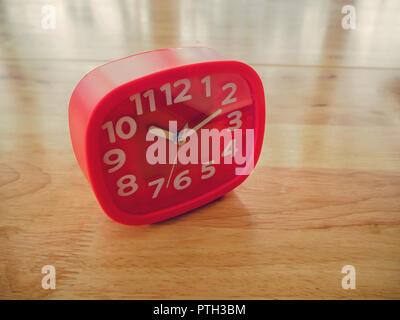 Red rectangle alarm clock on wooden table Stock Photo
