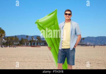 man in sunglasses with inflatable pool mattress Stock Photo