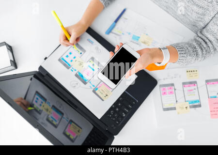 designer with smartphone working on user interface Stock Photo