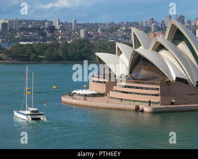 Sydney Opera House, from the South Tower of the Harbour Bridge, showing a large catamaran yacht passing the Opera House: Sydney, NSW, Australia Stock Photo
