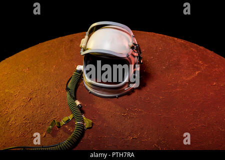 helmet from spacesuit lying on red planet in black cosmos Stock Photo