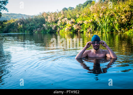 Swimmer Jens Roesner takes a pre-work wild swim in the river Avon at Warleigh Weir in Somerset. Stock Photo