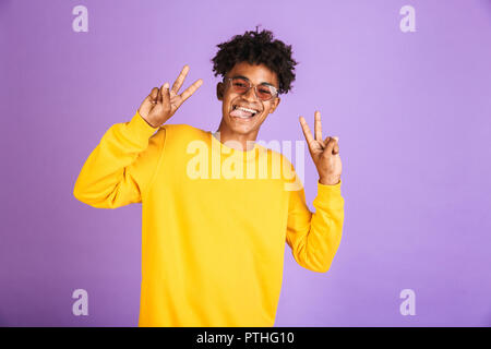 Portrait of a funny young afro american man in sweatshirt isolated, showing peace Stock Photo