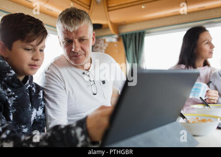 Father and son using digital tablet in motor home Stock Photo