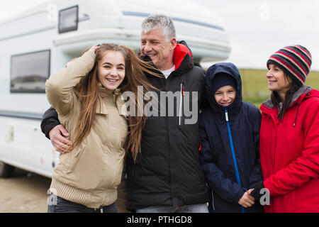 Portrait happy family in warm clothing outside motor home Stock Photo