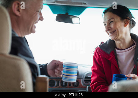 Happy couple drinking coffee in motor home Stock Photo