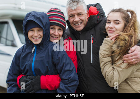 Portrait affectionate happy family in warm clothing outside motor home Stock Photo