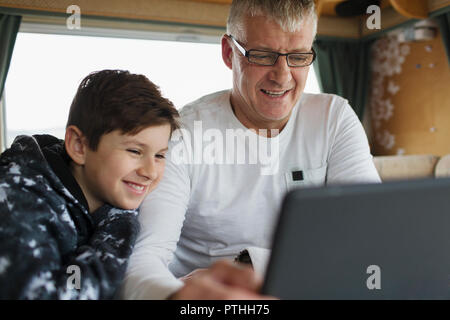 Father and son using digital tablet in motor home Stock Photo
