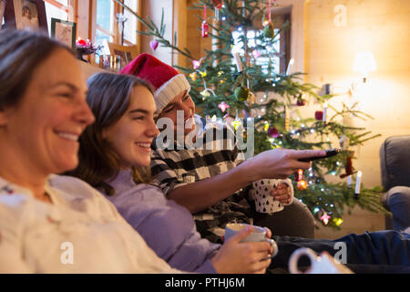 Family relaxing, watching TV in Christmas living room Stock Photo