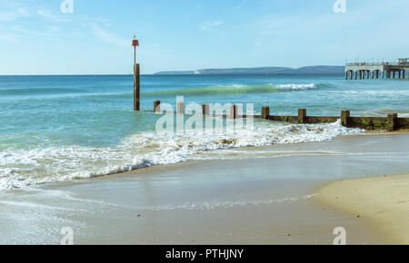 The waves wash over the Groynes at Boscombe in Bournemouth, UK. The Pier in the background. Taken on 7th October 2018. Stock Photo