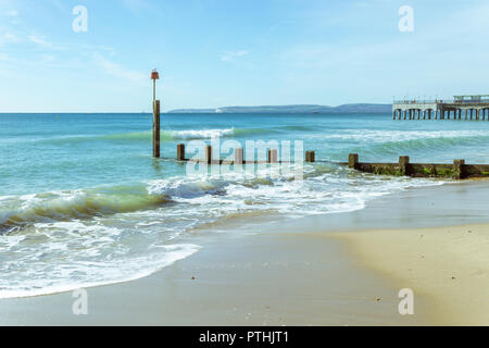 The waves wash over the Groynes at Boscombe in Bournemouth, UK. The Pier in the background. Taken on 7th October 2018. Stock Photo