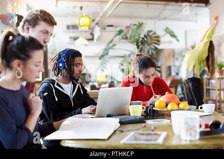 Young college student friends studying at kitchen table in apartment Stock Photo
