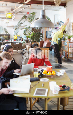 Young college student roommates studying and stretching in apartment Stock Photo