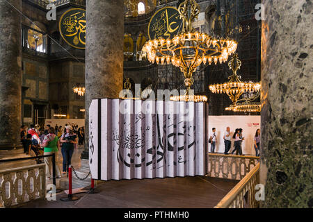 A large calligraphy artwork with chandelier above on display in the Hagia Sophia museum, Istanbul, Turkey Stock Photo