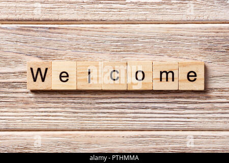 WELCOME word written on wood block. WELCOME text on table, concept. Stock Photo