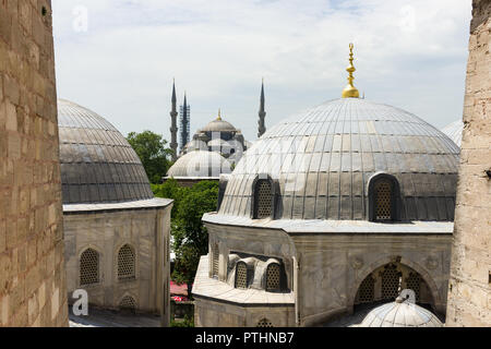 View of the exterior domed buildings that surround the Hagia Sophia museum, the minarets of the Blue Mosque can be seen in the background, Istanbul, T Stock Photo