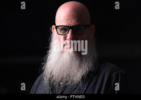 Portrait Of Bald Man With Gray Beard Outdoors At Night Stock Photo