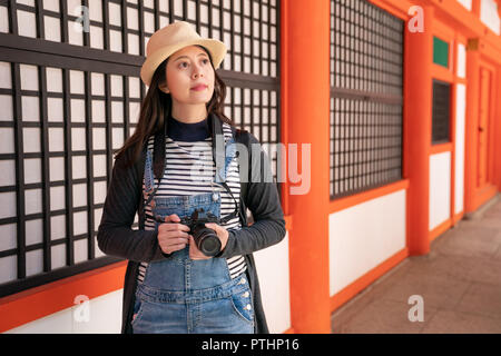 a confident female photographer looking at the amazing building and preparing to take photo of it Stock Photo