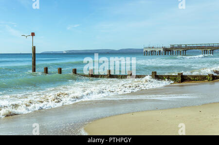 The waves wash over the Groynes at Boscombe in Bournemouth, UK. The Pier in the background. Taken on 7th October 2018. Stock Photo