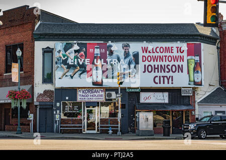 JOHNSON CITY, TN, USA-9/30/18: A welcome sign sponsored by Michelob  is posted prominently in a square in downtown, with two small businesses below. Stock Photo