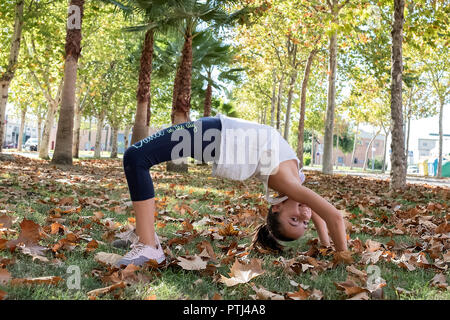 little girl making the bridge in a park Stock Photo