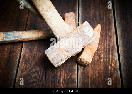 Close up of tree old used hammer on a rustic wooden background. Selective focus Stock Photo