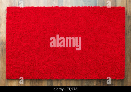 Blank Red Welcome Mat On Wood Floor Background Ready For Your Own Text. Stock Photo