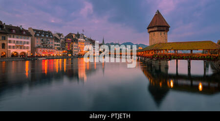 The Kapellbrücke (Chapel Bridge) is a covered wooden footbridge spanning diagonally across the Reuss in the city of Lucerne in central Switzerland. Stock Photo