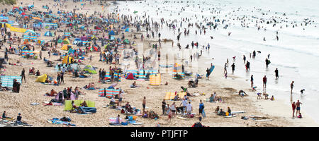A panoramic view of a very busy Fistral Beach during the Summer holidays in Cornwall. Stock Photo