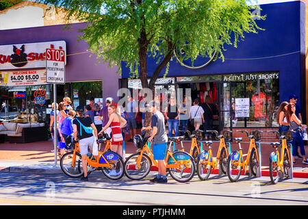 Group of people renting bicycles from the cycle station on E University Blvd to explore the area in Tucson AZ Stock Photo