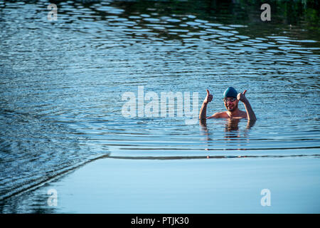 Wild swimmer Jens Roesner takes a pre-work wild swim in the river Avon at Warleigh Weir in Somerset. Stock Photo