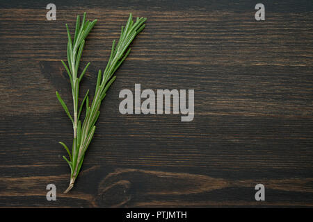 Rosemary Sprigs on a Dark Wood Background Stock Photo
