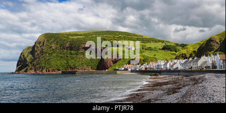 Stone beach and row of white houses of Pennan coastal fishing village on North Sea in Aberdeenshire Scotland UK with Black Hill sea cliff Stock Photo